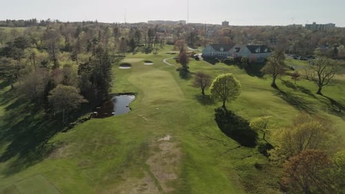 Aerial View Of Golf Course With Players And Groundskeepers In The Field