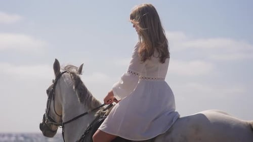 Girl Serenely Rides A Horse At A Beach