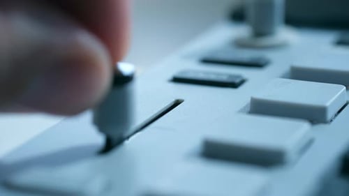 Professioneller Tontechniker, der die Fader-Lautstärke der Audioeingänge ausbalanciert, digitales Gerät verwenden