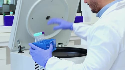 Scientist Using Centrifuge in Medical Laboratory