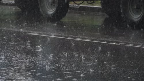 Large Drops of Water Fall on Asphalt Road Near Parked Truck