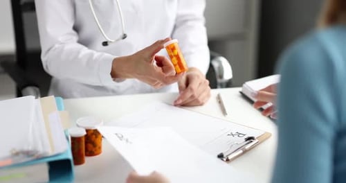 Le médecin remet un pot de médicament au patient