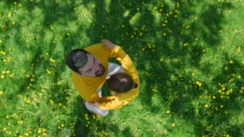Father and child enjoying a playful day outdoors in a field of flowers