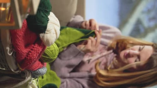 Woman Knitting at Home Relaxing on Sofa