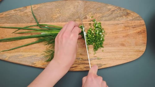 Slicing Green Onions and Dill on a Cutting Board