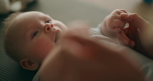 Adorable Baby Lying Down and Wiggling Hands