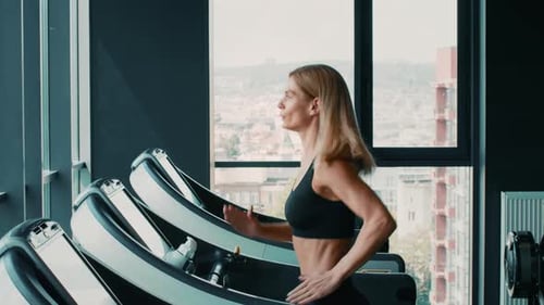 Warm Up at Gym Side View Shot of Active Woman Athlete Running on Treadmill Practicing Cardio