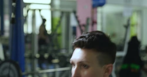 A woman trains himself in the gym performing both free-body exercises, such as push-ups and abdomi