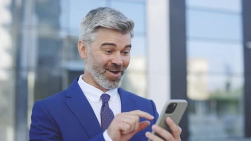 Man in Suit Using Smartphone Outdoors