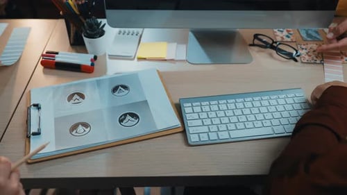 Creative workspace with a person using a keyboard, colorful stationery, and desi