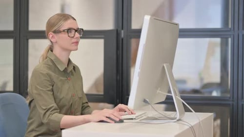 Smiling Woman Working at Computer in Office