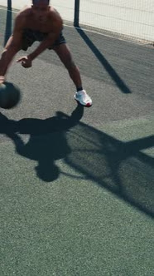 Young Adult Male Dribbling Basketball on Urban Court