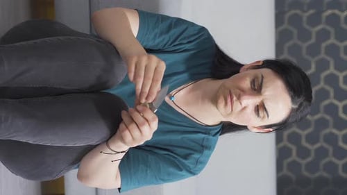 Woman Carefully Trims Fingernails with Knife