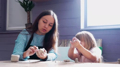 Woman and Child Crafting with Clay Indoors