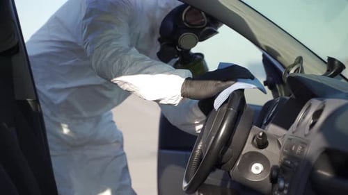 Person in Hazmat Suit Cleaning Car Interior