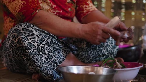 Closeup Southeast Asian Woman Peeling and Crushing Ingredients to Mix Them to Make a Traditional