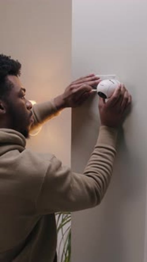 Man Puts Security Camera on Wall Fastening
