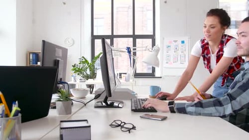 Kreatives multiethnisches Team, das in einem modernen Büro mit Technologie zusammenarbeitet