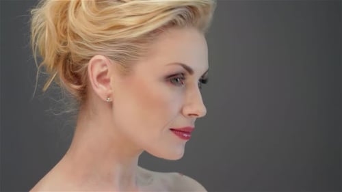 Elegant Portrait of a Stunning Blonde Woman Against a Soft Gray Backdrop
