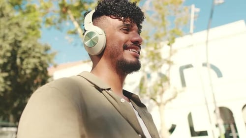 Close up, young student in headphones works on pc laptop while sitting on bench
