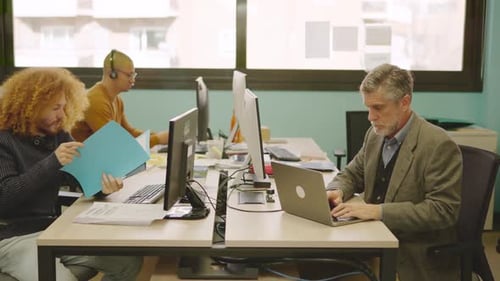 Office Workers at Desks Using Technology