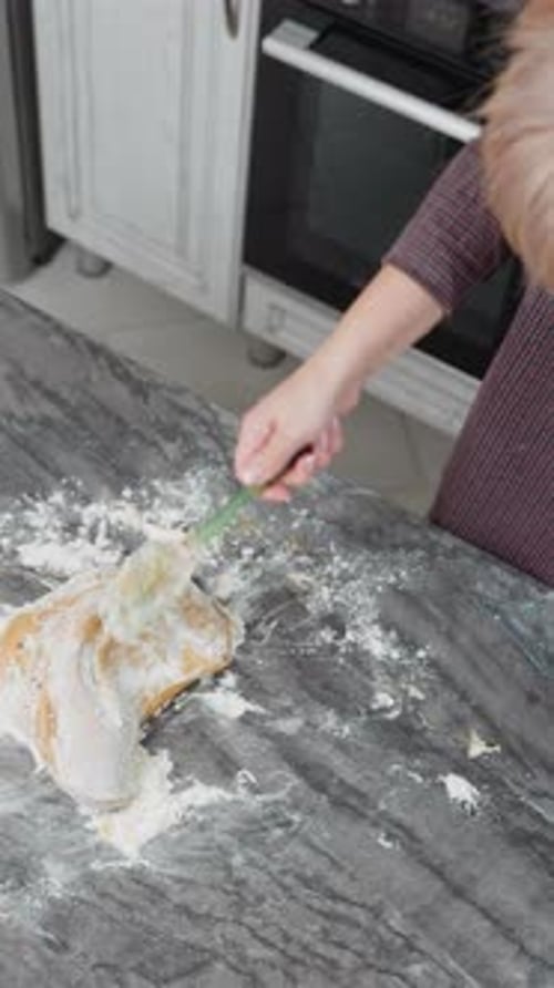 Overhead View of Baker Kneading Dough on Floured Tiled Table