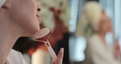 Close Up Young Woman Using Jade Facial Roller for Skin Care in Her Bedroom Blonde Girl Using Natural