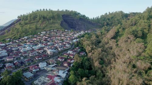Aerial View of Dense Village Near Landslide and Tropical Forest