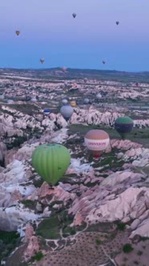 Vertical Video Hot Air Balloons Fly Over the Mountainous Landscape of Cappadocia Turkey
