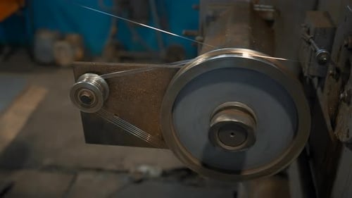 Rotierende Spulen, die den Draht im Werk aufwickeln. Industriewerkstatt mit Draht auf rotierenden Maschinen