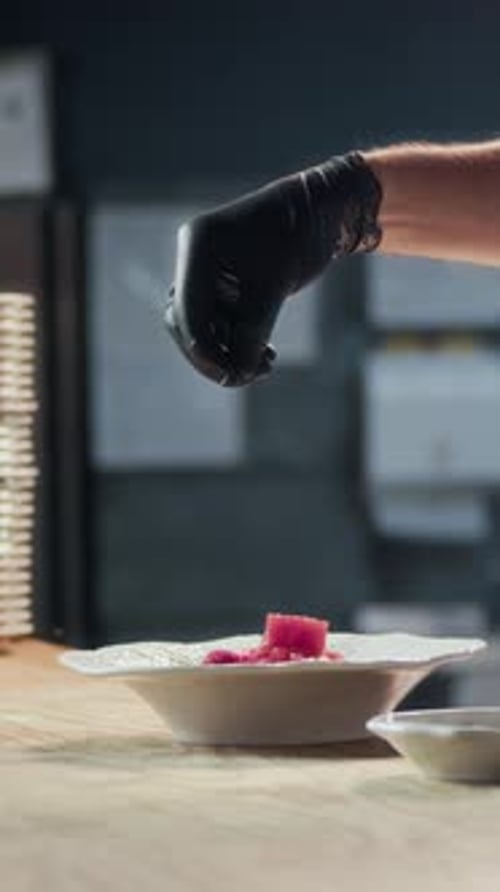 Anonymous Chef Seasoning Tuna Dish Serving at Restaurant Kitchen