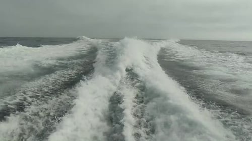 wake of water seen from behind of fast moving motor boat in a clear sky day,Blue sea , water surface