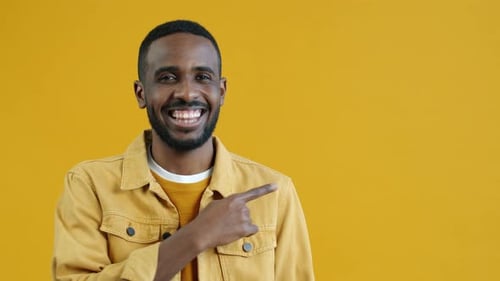 Man Points to Left on Yellow Background