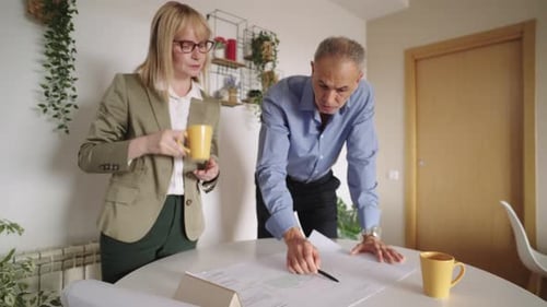 Professional Architects Analyzing Building Blueprints in the Office