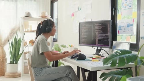 Asia lady IT development programmer listen music enjoy work type on keyboard coding programming.