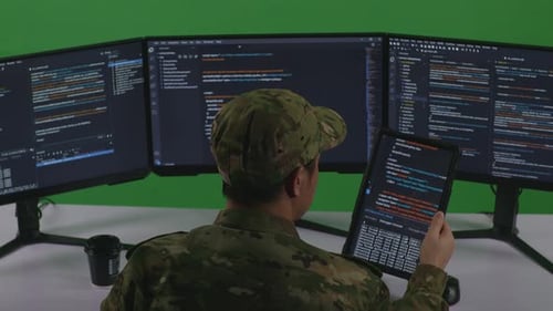Man Soldier Working With Tablet While Write Code With Multiple Computer Screens In Green Screen