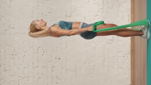 Woman Exercises Core with Resistance Band Bridge
