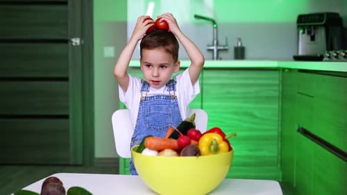 Young Boy Plays with Tomatoes in Bright Kitchen