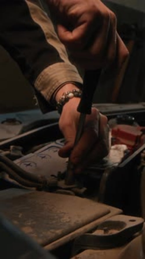 Hands of Specialist Repairing Car with Tool in Garage