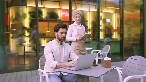 Waiter Showing Tablet To Customer