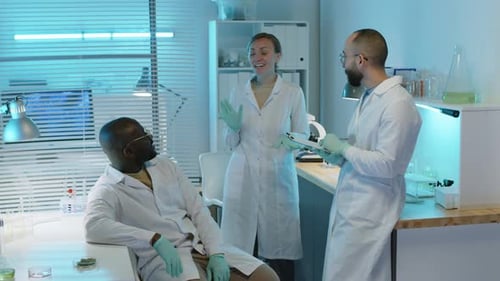 Female Lab Scientist Chatting with Colleagues at Workplace