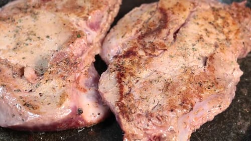 Juicy Pork Chops Searing in Pan Close Up