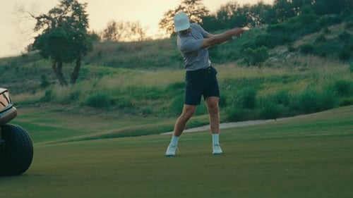 Man Practices Golf Swing on Picturesque Green Course