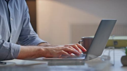 Man Typing on Laptop in Modern Office Setting