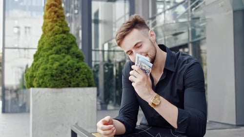 Cheerful Happy Business Man Counting Money at Street Outdoor