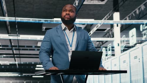Server Farm Programmer at Workplace Desk Using Laptop to Optimize Electronics