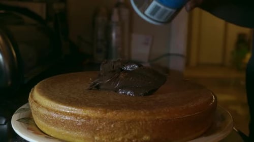 Cake Being Frosted with Chocolate Frosting