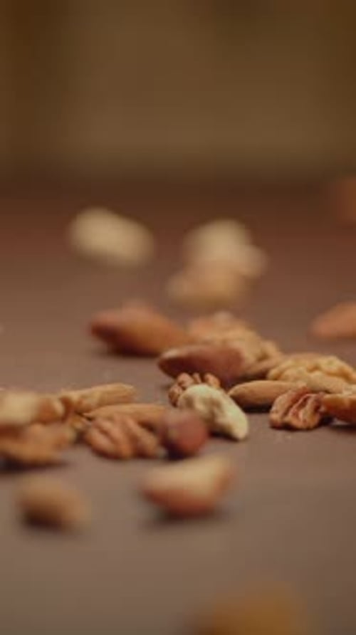 Nuts Dropping Slowly onto a Brown Surface