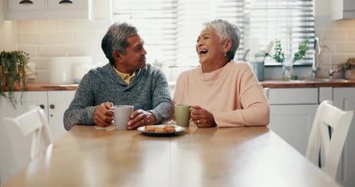 Senior Couple Laughing and Enjoying Coffee at Home