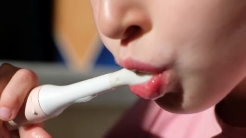 Child Brushing Teeth with Electric Toothbrush, Close Up